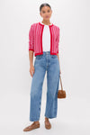 Young woman in a Pink & Red Knit Cassie Cardigan, effortlessly stylish over a white tee with classic high-waisted jeans, embodying Tuckernuck's fun, high-end fashion.
