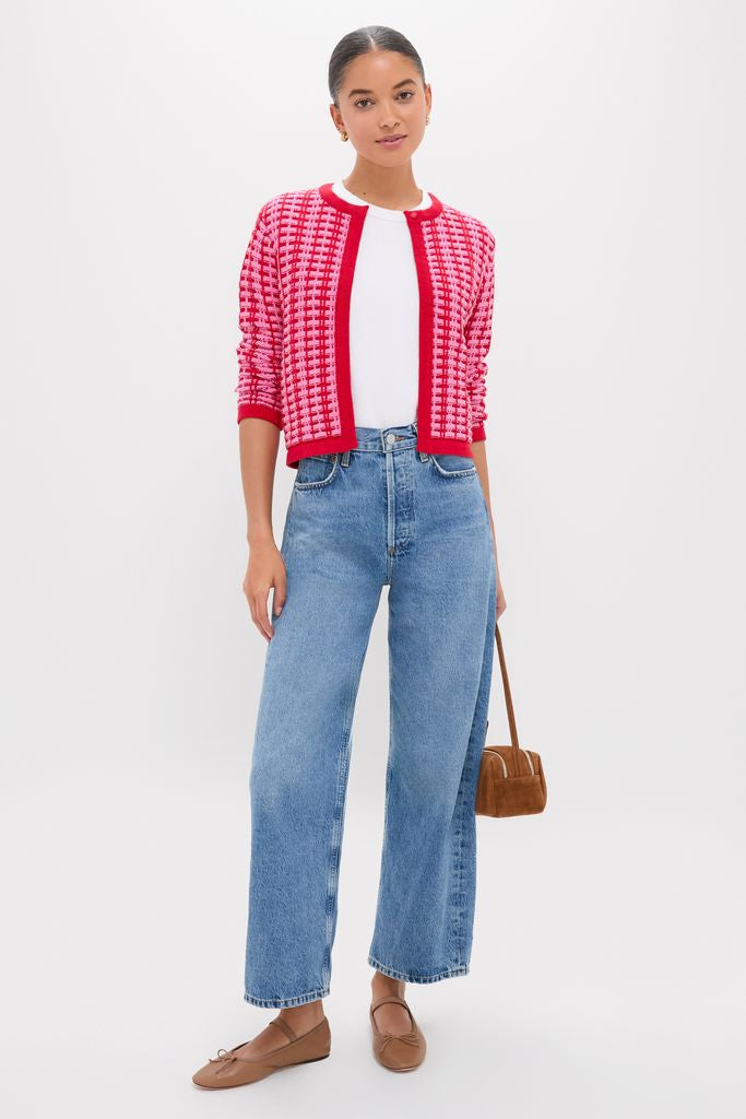 Young woman in a Pink & Red Knit Cassie Cardigan, effortlessly stylish over a white tee with classic high-waisted jeans, embodying Tuckernuck's fun, high-end fashion.