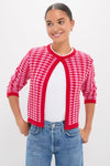 Young woman in a classic, effortless Pink & Red Knit Cassie Cardigan, showcasing its fun, high-end design with a keyhole opening and three-quarter sleeves.