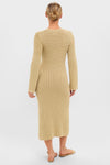 Person in a classic Gold Knit Amanyara Maxi Dress, showcasing its effortless, form-fitting design with long sleeves. Paired with thong-style sandals for a fun, high-end look.