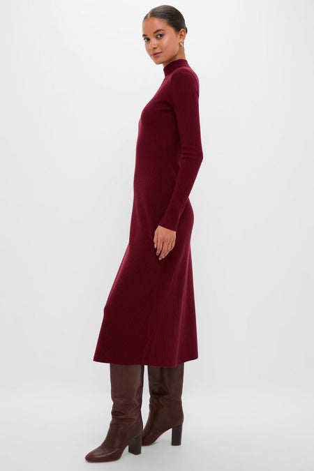 Woman models the classic Oxblood Knit Conrad Midi Swing Dress with a mock turtleneck and flared hem, paired with knee-high leather boots for an effortless, high-end look.