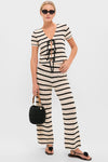 Model in Black & Tan Stripe Portimao Pants, showcasing classic, effortless coastal style with matching top and chic accessories. Perfect for fun, high-end getaways.