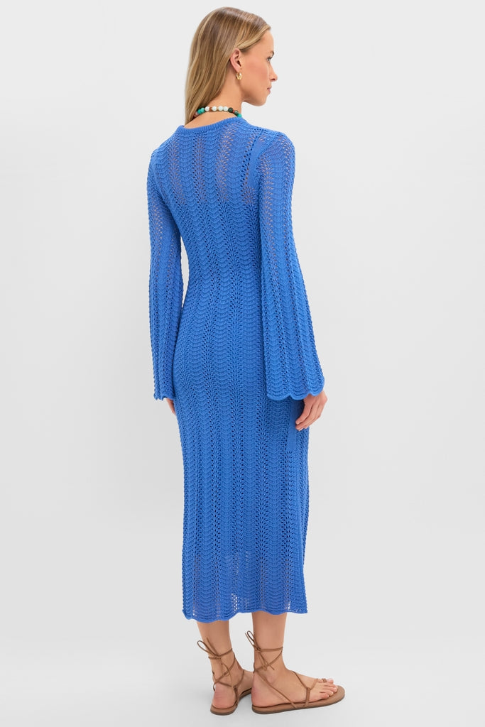 Woman in a cobalt-blue Cerulean Knit Comporta Midi Dress with chevron pattern, flared sleeves, and lace-up sandals, embodying effortless, high-end style.