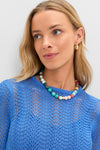 A young woman models a classic, effortless Cerulean Knit Comporta Midi Dress, paired with fun multicolored beads and high-end gold hoop earrings.