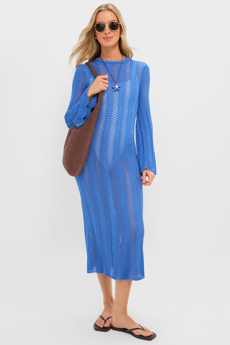 Young woman in a classic, cobalt Cerulean Knit Comporta Midi Dress, exuding effortless elegance with a slouchy shoulder bag and round sunglasses.