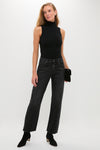 Model in chic Silver Screen Lexi Bowed Straight jeans, styled with rhinestones, paired with a sleeveless black turtleneck bodysuit, exuding an effortless, high-end, and classic look.