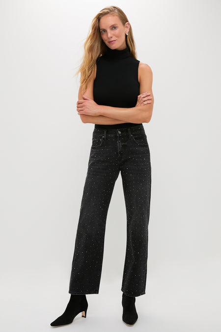 Woman in classic Silver Screen Lexi Bowed Straight jeans with rhinestones, paired with a sleeveless black turtleneck and heeled ankle boots, exuding effortless, high-end style.