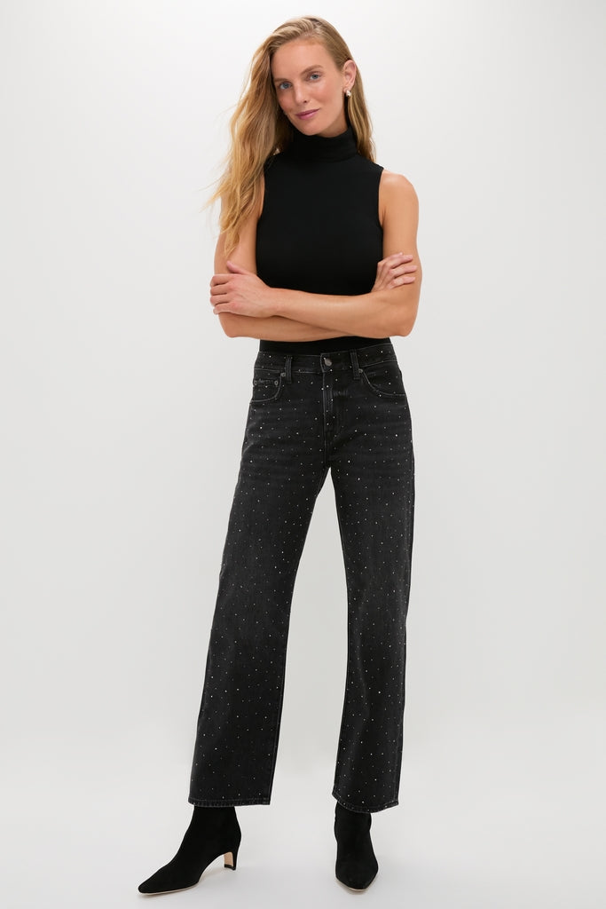 Woman in classic Silver Screen Lexi Bowed Straight jeans with rhinestones, paired with a sleeveless black turtleneck and heeled ankle boots, exuding effortless, high-end style.