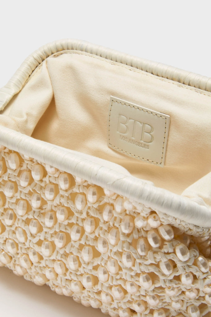 White Perola Clutch: A classic, cream-colored woven handbag with knotted lattice and bead detailing, exuding effortless high-end style. Perfect for adding fun sophistication to any ensemble.