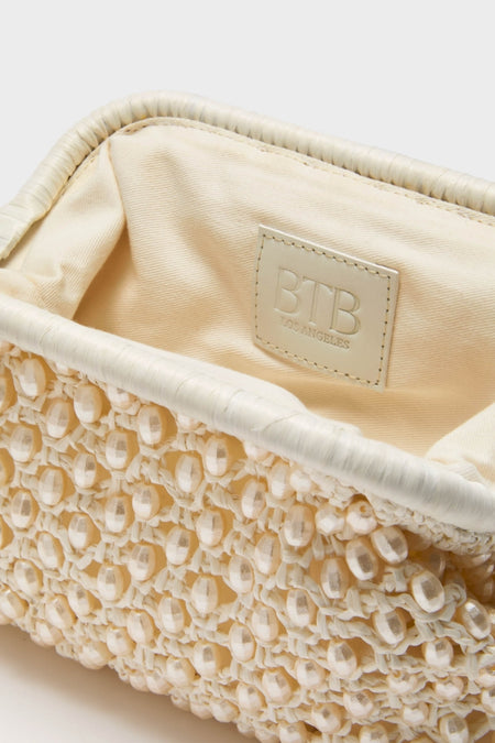 White Perola Clutch: A classic, cream-colored woven handbag with knotted lattice and bead detailing, exuding effortless high-end style. Perfect for adding fun sophistication to any ensemble.