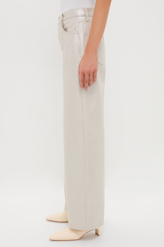 Model showcasing classic, high-end Champagne Luster Tate trousers with a high rise and bowed wide leg, paired with nude-tone mules for an effortless, fun look.