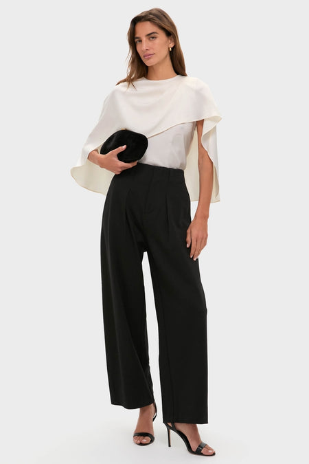 Model in classic, high-rise Night Out Eden Pleated Ponte Trouser with wide-leg design, styled effortlessly with asymmetrical cape top and stiletto sandals, exuding high-end, fun elegance.
