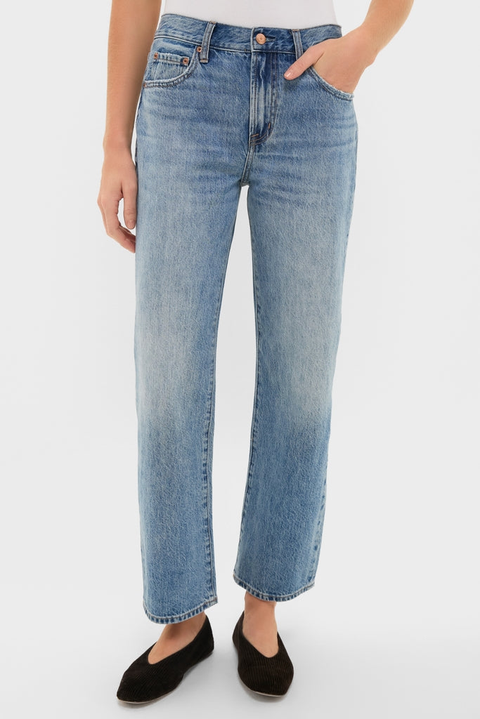 Metropolis Lexi Mid Rise Bowed Straight jeans feature classic five-pocket design, subtle fading, and clean hem, offering an effortless, high-end look modeled with fun black slip-on flats.