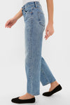 Metropolis Lexi Mid Rise Bowed Straight jeans, modeled in profile, showcase a classic, effortless shape with a clean hem for a fun, high-end look.