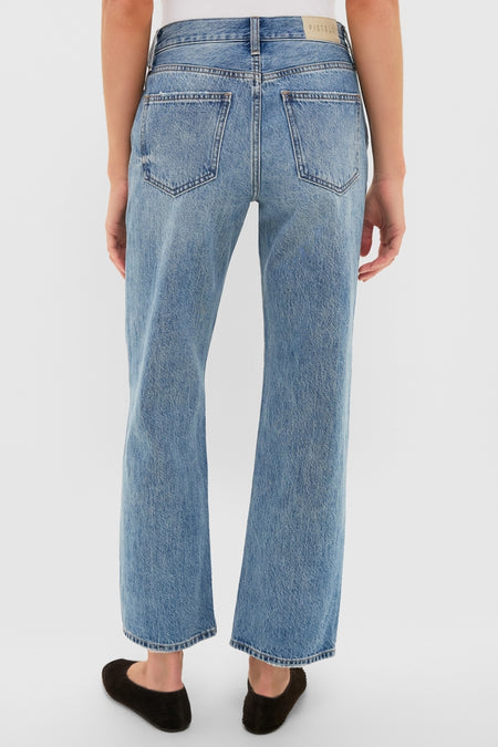 Back view of Metropolis Lexi Mid Rise Bowed Straight jeans showcasing classic, effortless style with patch pockets and a leather logo. Paired with black slip-on shoes.