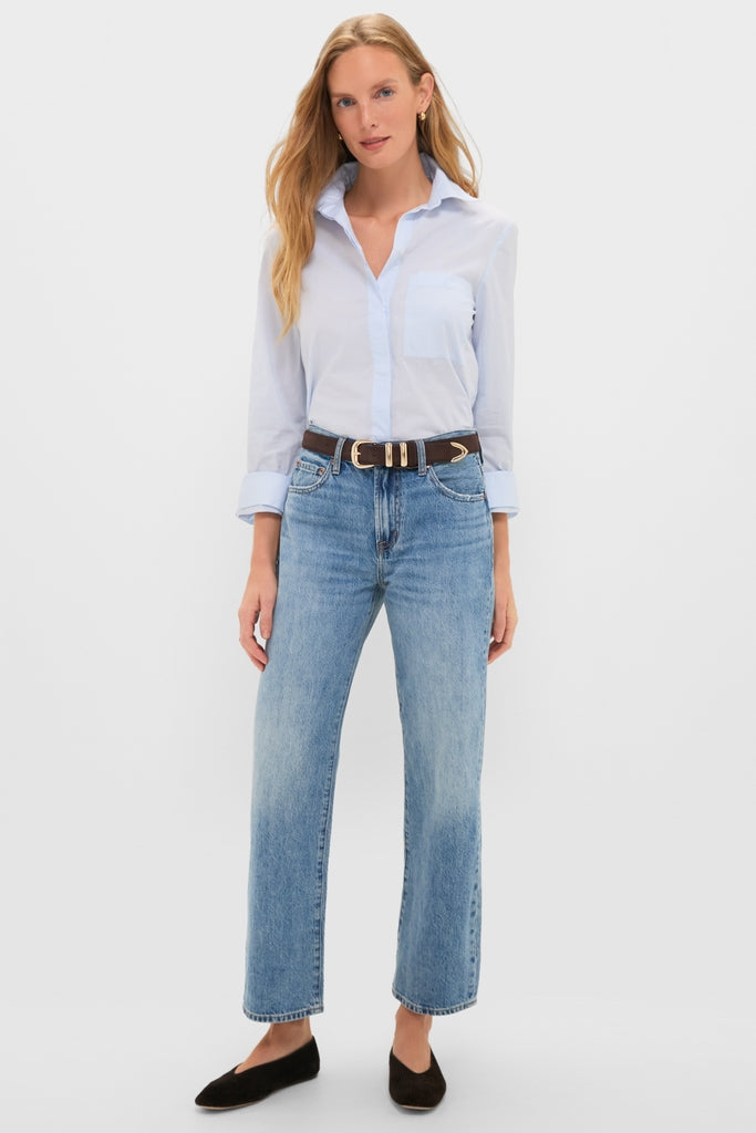 Woman wearing Metropolis Lexi Mid Rise Bowed Straight jeans with a light-blue button-down shirt, black flats, and a brown belt. Classic, effortless, high-end style.
