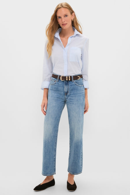 Woman wearing Metropolis Lexi Mid Rise Bowed Straight jeans with a light-blue button-down shirt, black flats, and a brown belt. Classic, effortless, high-end style.