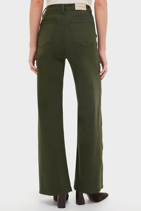 Model in classic, high-end Laurel Penny High Rise Wide Leg jeans with frayed hem, showcasing an effortless, fun style, paired with a tucked-in top and heeled boots.