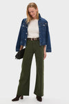 Woman models classic, effortless Laurel Penny High Rise Wide Leg trousers with raw hem, styled with a denim jacket and dark brown accessories, embodying a fun, high-end look.