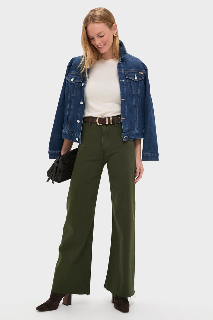 Woman models classic, effortless Laurel Penny High Rise Wide Leg trousers with raw hem, styled with a denim jacket and dark brown accessories, embodying a fun, high-end look.
