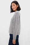 Young woman in profile wearing the Charcoal Diamonte Aura Sweater, featuring a relaxed fit, classic crew neckline, and crystal embellishments, embodying effortless, fun, high-end style.