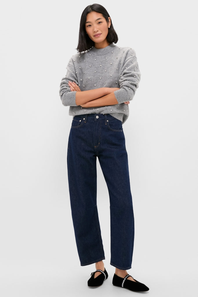 Woman in a Charcoal Diamonte Aura Sweater with pearl accents, paired with dark jeans and velvet flats, showcasing an effortlessly classic and high-end style.