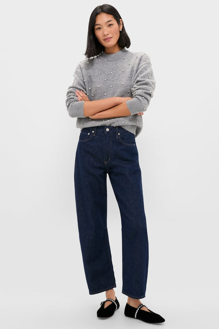 Woman in a Charcoal Diamonte Aura Sweater with pearl accents, paired with dark jeans and velvet flats, showcasing an effortlessly classic and high-end style.