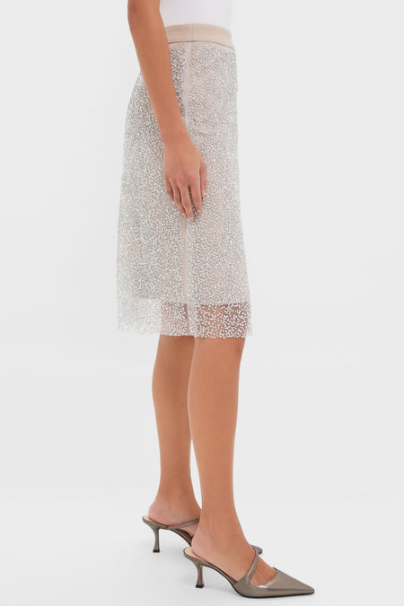 Woman wearing the Blush Sparkle Belle Slip Skirt, a classic, beaded pencil skirt paired with metallic taupe mules, showcasing an effortless and high-end look.