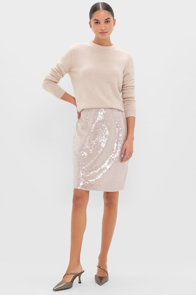 Model wearing the classic Champagne Sequin Clayton Midi Skirt, featuring an effortless pencil silhouette with sequins, styled with a light-beige sweater and metallic slingback pumps.
