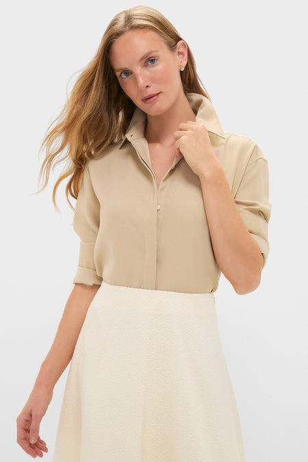 Model in a classic Gold Noelle Button Down, showcasing its effortless gold shine and relaxed fit, paired with a high-end textured skirt for a fun, stylish look.