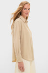 Woman in profile wearing the Gold Noelle Button Down, a classic, effortless blouse with a relaxed fit and gold shine, epitomizing fun, high-end style.