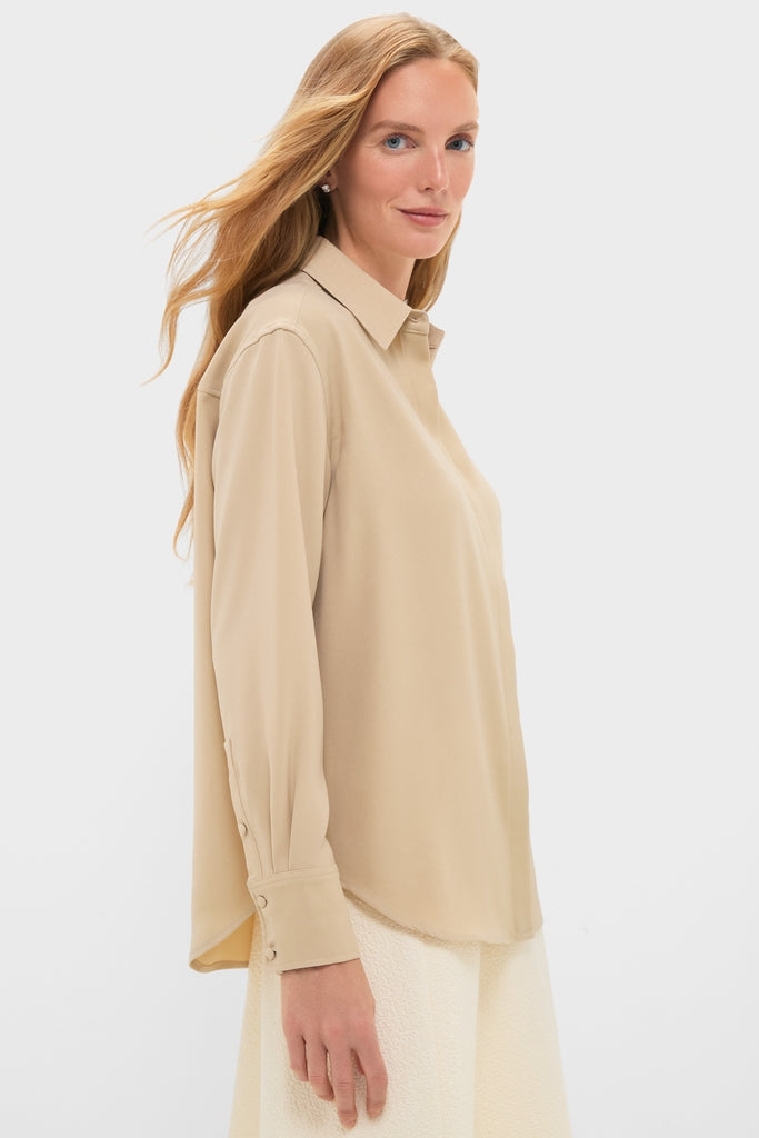 Woman in profile wearing the Gold Noelle Button Down, a classic, effortless blouse with a relaxed fit and gold shine, epitomizing fun, high-end style.