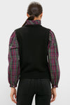 Back view of a woman in the Tartan Ella Sweater Blouse, featuring a classic sleeveless knit vest over a plaid shirt, embodying effortless, high-end style for festive occasions.