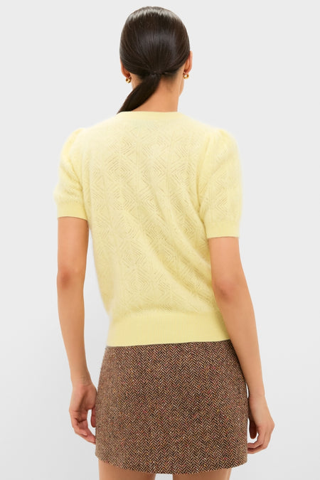 Model wears the Lemongrass Brushed Merino Wool Puff Sleeve Lexie Sweater, showcasing its classic, effortless style with puff sleeves and diamond knit, paired with a herringbone mini skirt.