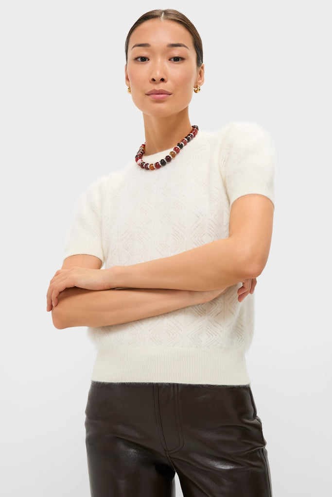 Model wears the classic Ivory Brushed Merino Wool Puff Sleeve Lexie Sweater, featuring puff sleeves and diamond knit texture, paired effortlessly with high-end black leather pants.