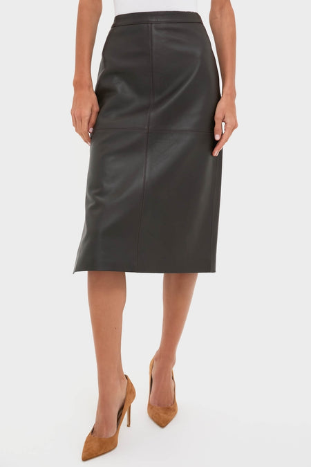 Woman wearing the classic Demitasse Leather Elene Midi Skirt, effortlessly styled with brown suede pumps, epitomizing fun and high-end fashion.
