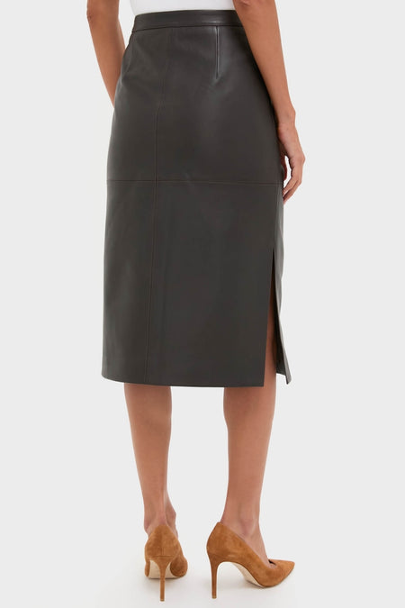 Woman showcasing the classic Demitasse Leather Elene Midi Skirt, high-waisted with a side slit, paired with tan stiletto pumps for an effortless, high-end look.