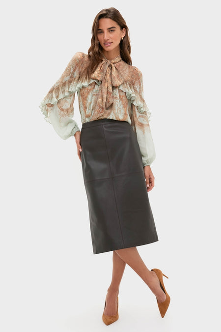 Model in a high-end, classic Demitasse Leather Elene Midi Skirt paired with an effortless paisley sheer blouse, embodying Tuckernuck's fun and confident style.