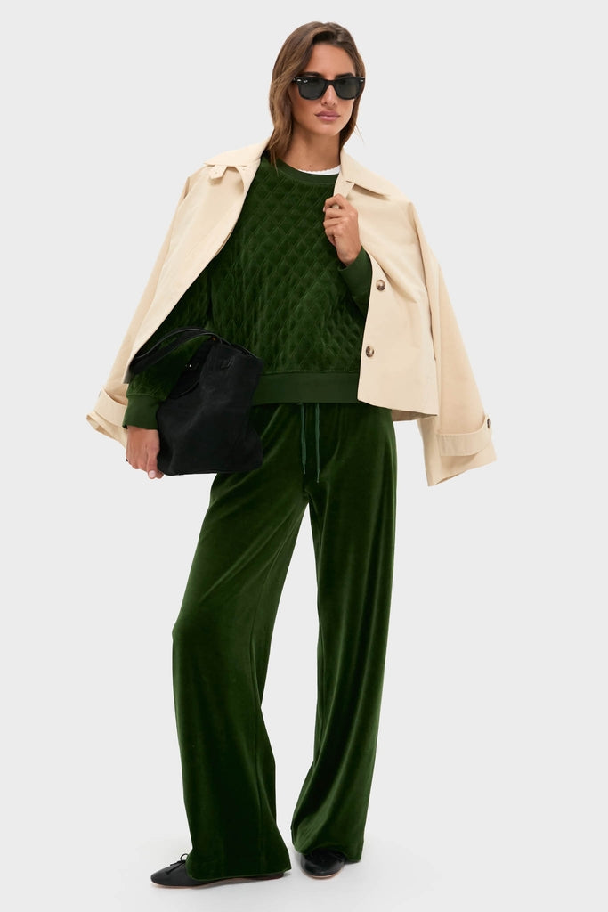 Model wearing classic Douglas Fir Velour Bennett Pullover; effortlessly chic loungewear with quilted body and relaxed fit, paired with matching pants and stylish tote.