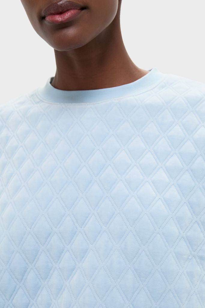Person wearing the Blue Fog Velour Bennett Pullover, showcasing its classic diamond-quilted texture and effortless style, perfect for a fun, high-end loungewear look.