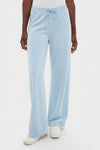 Model wearing classic Blue Fog Velour Jane Pant with wide-leg and elasticated waistband, paired with white sneakers, embodying effortless, fun, and high-end loungewear style.