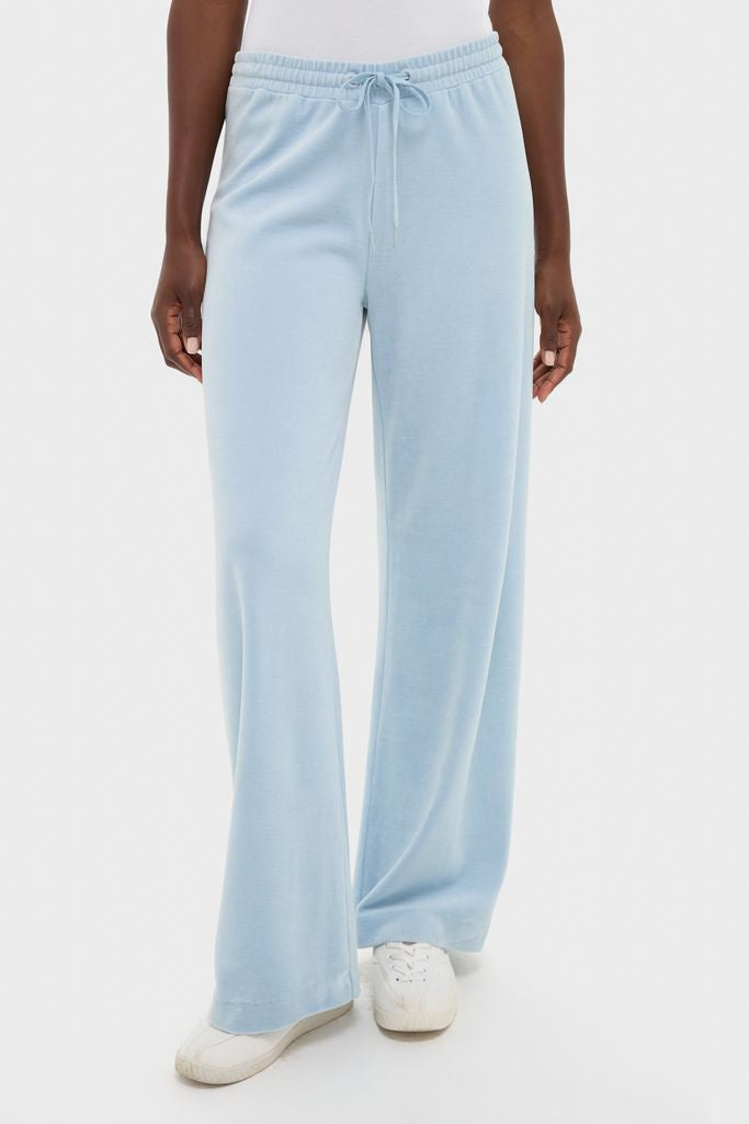 Model wearing classic Blue Fog Velour Jane Pant with wide-leg and elasticated waistband, paired with white sneakers, embodying effortless, fun, and high-end loungewear style.