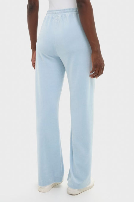 Back view of the Blue Fog Velour Jane Pant, featuring an elastic waistband and wide-leg silhouette, paired with white sneakers for a classic, effortless, high-end look.