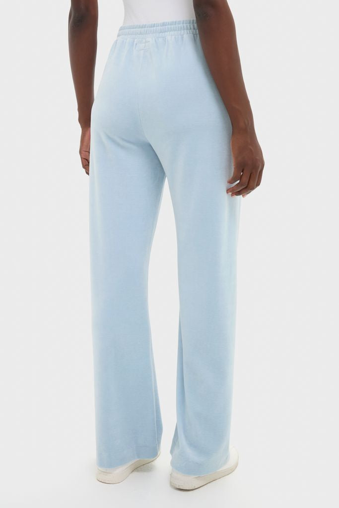 Back view of the Blue Fog Velour Jane Pant, featuring an elastic waistband and wide-leg silhouette, paired with white sneakers for a classic, effortless, high-end look.