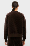 Back view of a person in a classic, quilted Chocolate Brown Velour Bennett Pullover with matching pants, embodying effortless, high-end style and fun casual elegance.