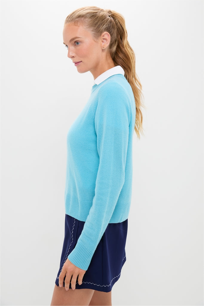 Young woman in profile wears a classic, high-end Bright Blue Washable Cashmere Malcolm Crewneck with raglan sleeves, effortlessly styled over a white collared shirt.