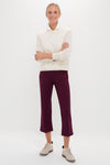 Model in a classic, effortless ensemble featuring the Buttercream Washable Cashmere Malcolm Crewneck, styled over a white shirt with burgundy trousers, exuding a high-end, fun appeal.