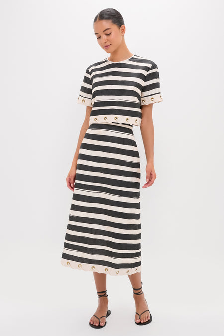 Model wearing the classic Black Stripe Story Pencil Skirt, featuring effortless grommet detailing and a confident silhouette, paired with a matching top and flat sandals.