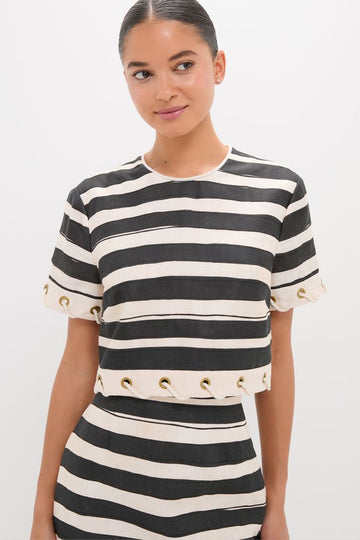 Woman in a classic Black Stripe Story Top, featuring effortless style with short sleeves and grommet detailing, embodying high-end fashion with a fun, confident twist.