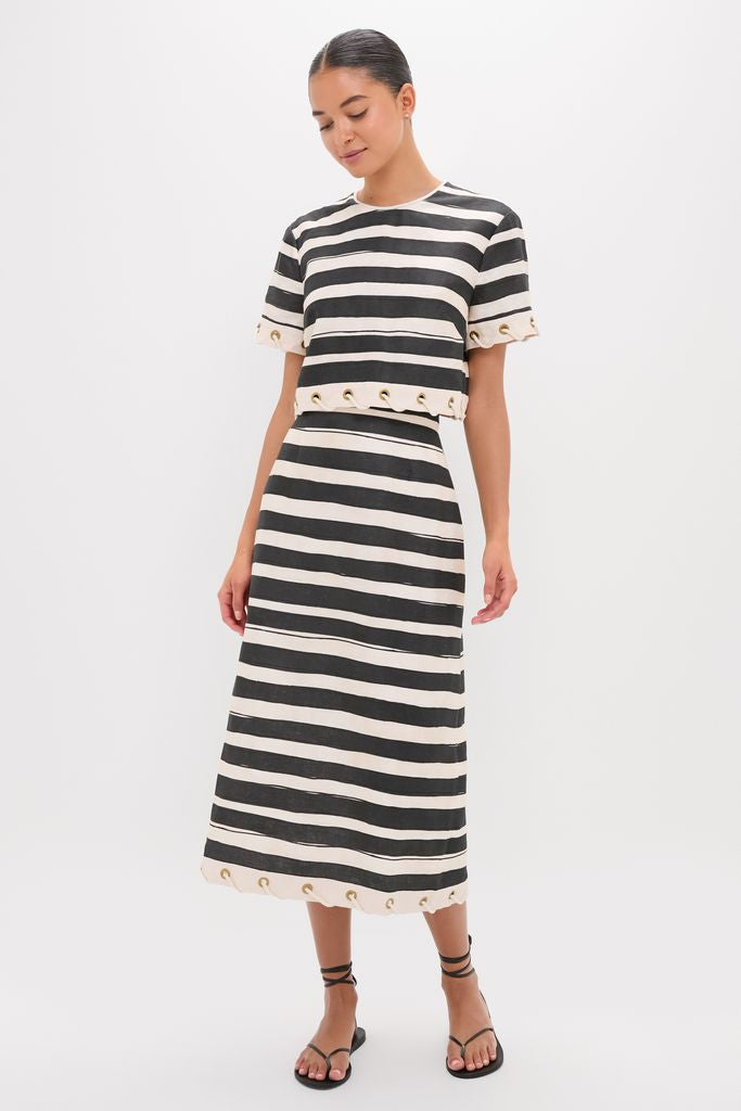 Model in Black Stripe Story Top, a classic, effortless two-piece with eyelet accents, paired with a midi skirt and strappy sandals, exuding fun, high-end style.